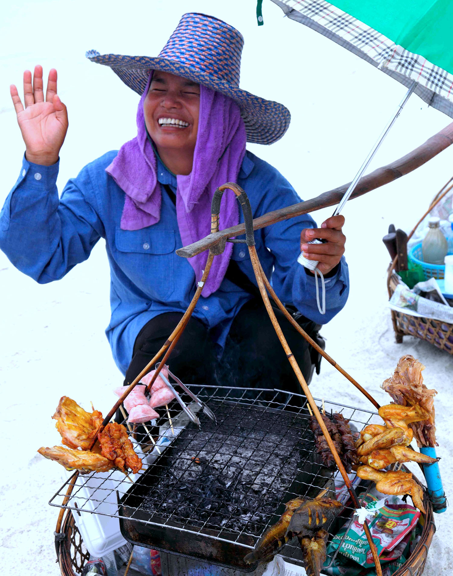 Thai woman, beach vendor, selling fried chicken.