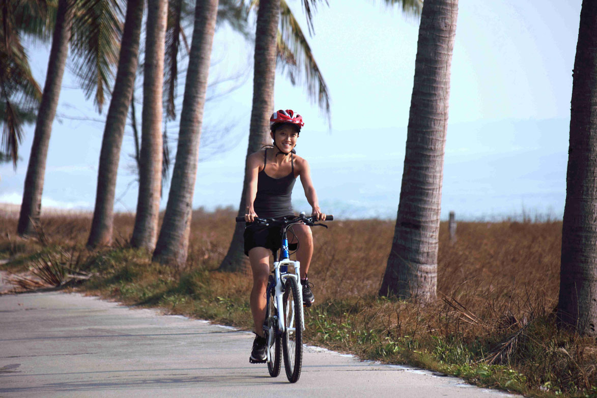 Tourists cycling beside Gulf of Thailand.